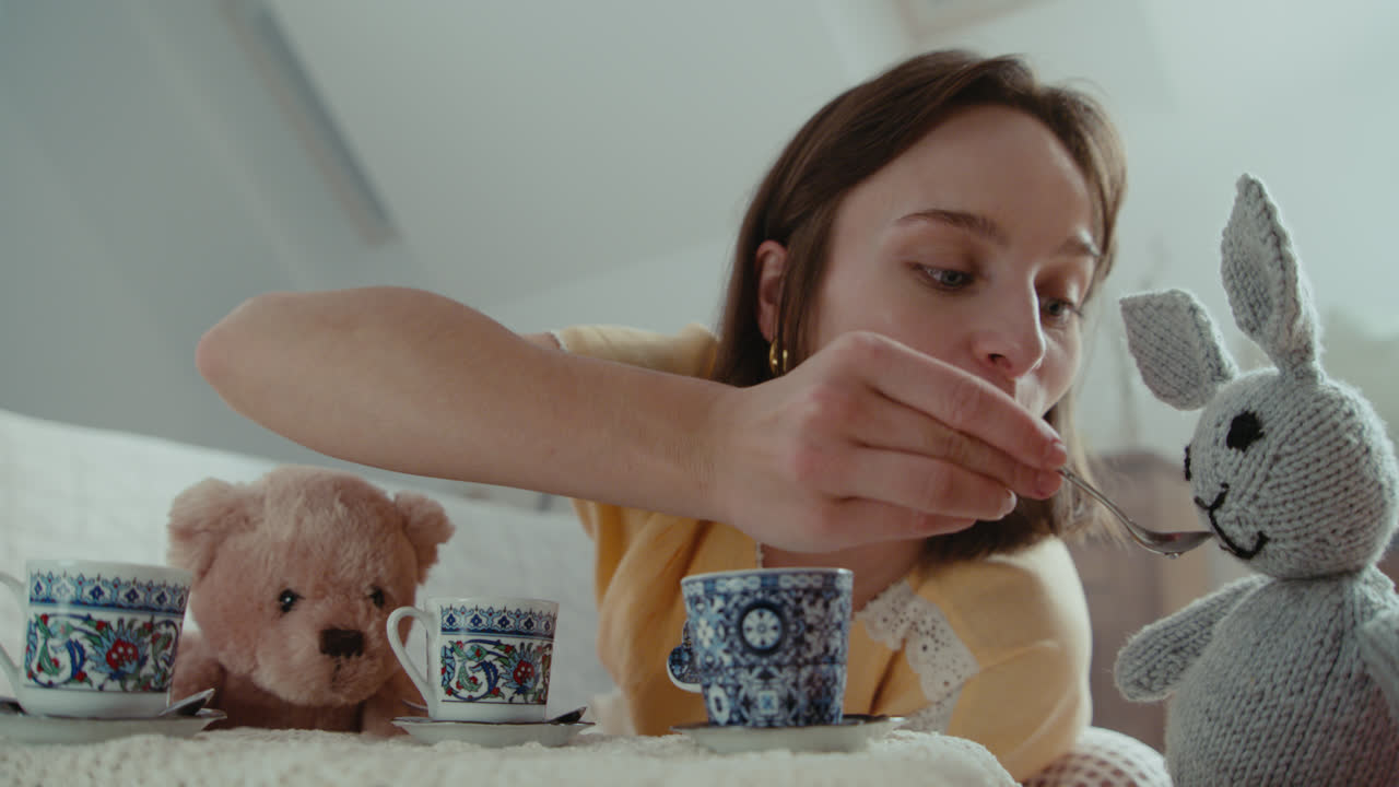 A girl playing with dolls in her room