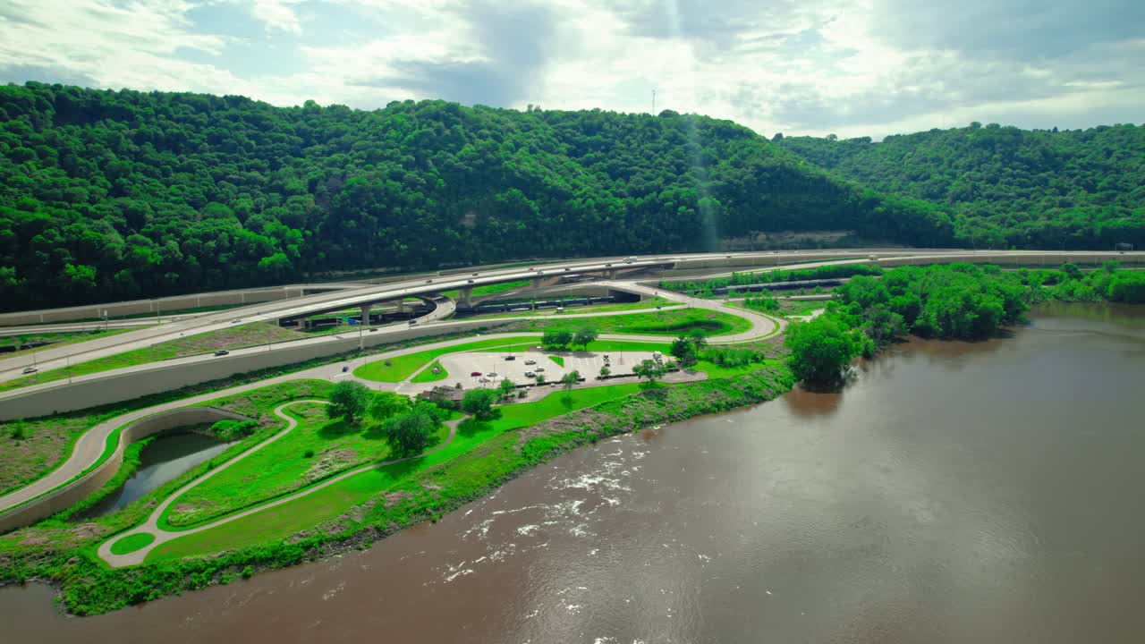 Aerial view of Minnesota Welcome Center Rest Stop near the Mississippi River, surrounded by green hills.