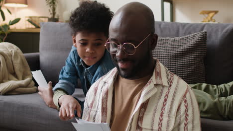 Man-and-boy-looking-at-pictures-at-home