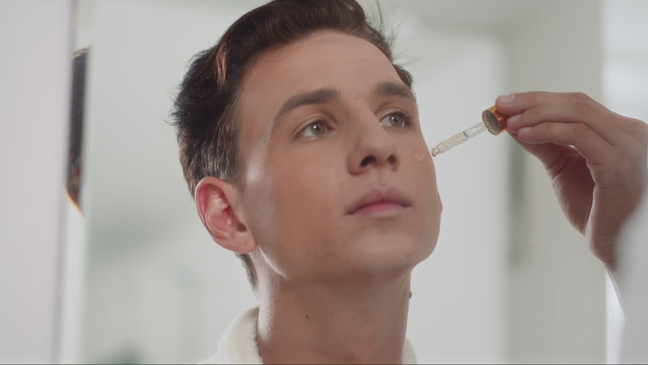 Attractive Man Applying Hydrophilic Oil on Face