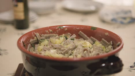 pasta italiana caliente pizzoccheri en una olla de cerámica cubierta con tela blanca - primer plano, cámara lenta