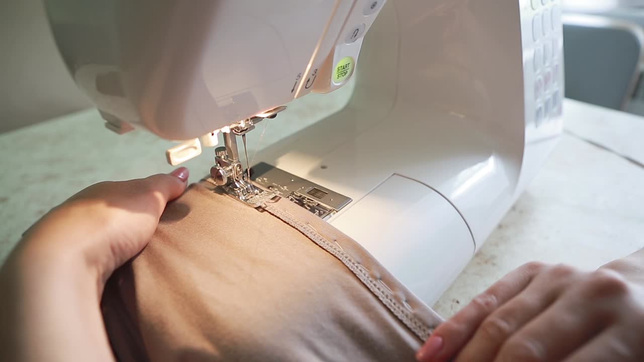 Seamstress at the Table. Close up of sewing machine working part with cloth