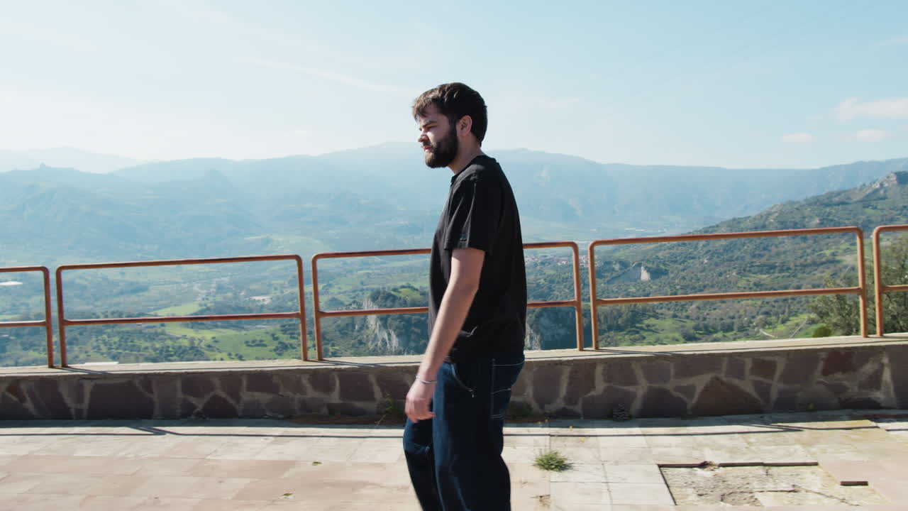 Giovane uomo che cammina nel parco con vista sul paesaggio della Calabria