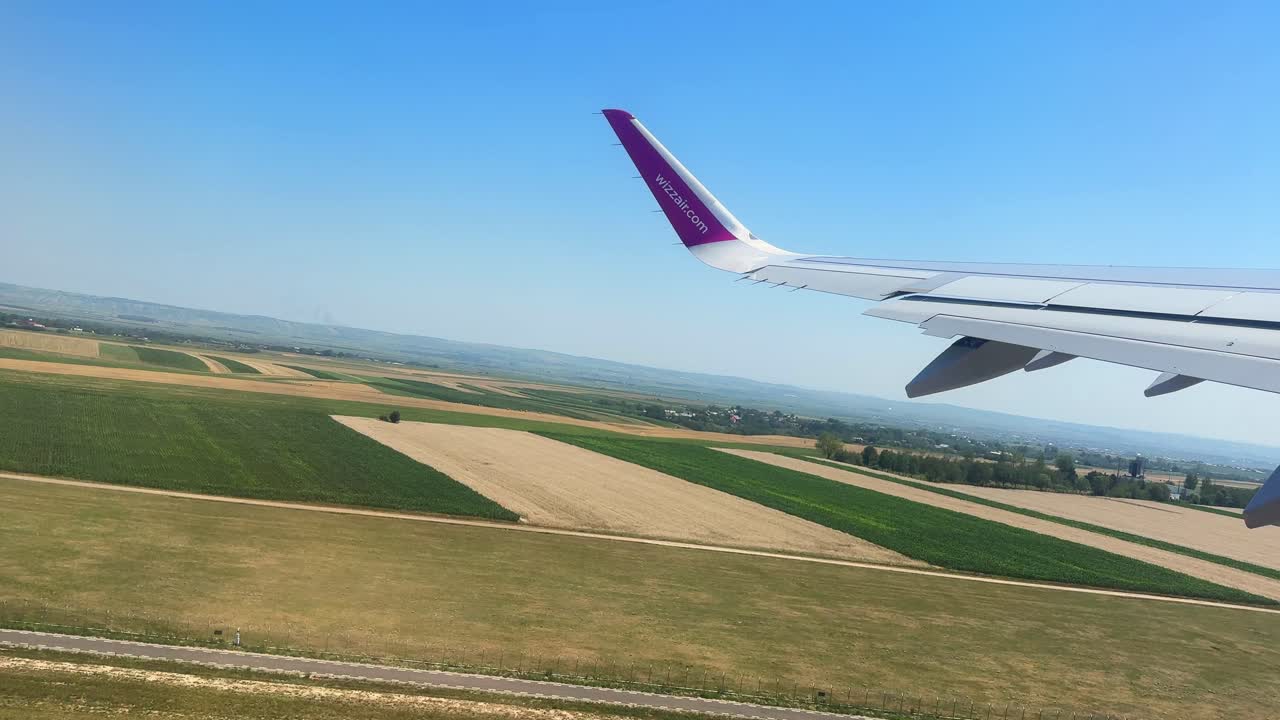 Plane window view takeoff Suceava Airport in Romania, fly airplane wing view