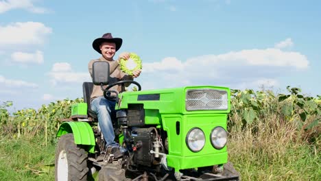 male agronomist near a sunflower plantation he is sitting in a tractor and having fun funny man male agronomist near a sunflower plantation he is sitting in a tractor and having fun funny man farmer joking smiling joyful man