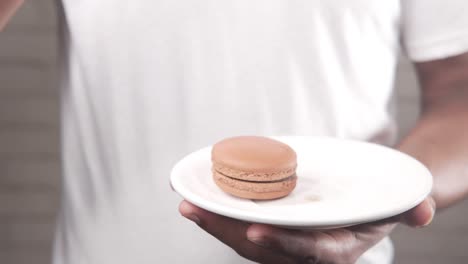 person holding chocolate macarons