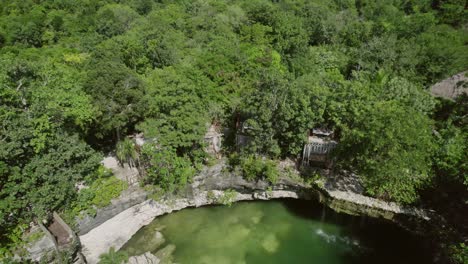 aerial view of a cenote surrounded by lush forest in riviera maya