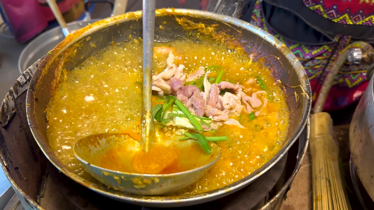 A vibrant street food scene with a vendor preparing suki in a bubbling pan, showcasing traditional Thai cooking