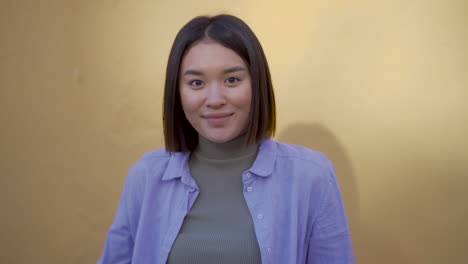 Portrait-Of-Young-Happy-Woman-Waving-Hand-At-Camera