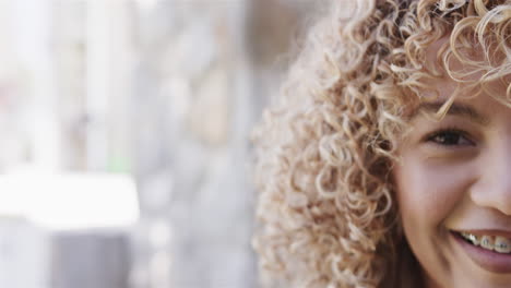 Close-up-of-a-young-biracial-woman-smiling-brightly,-with-copy-space