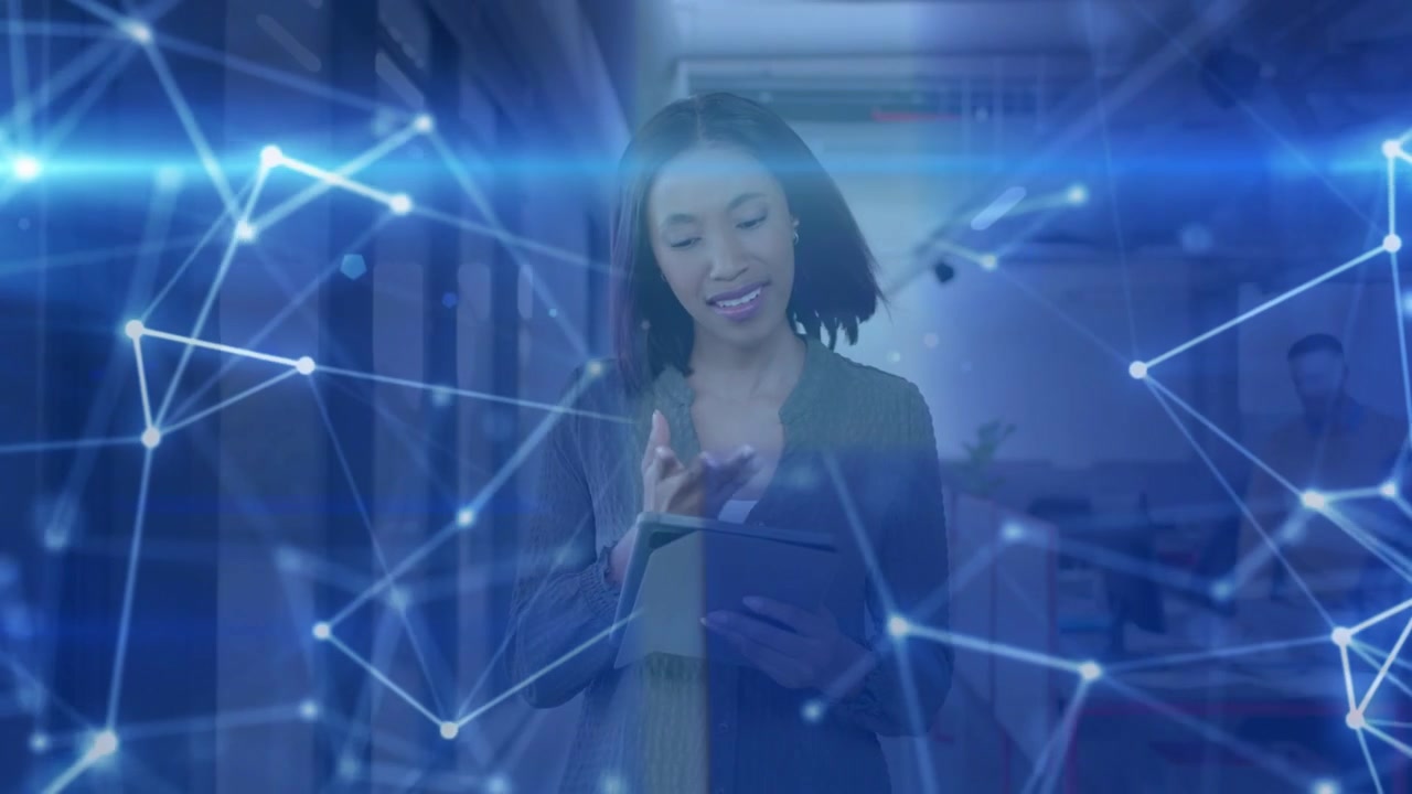 Woman tapping tablet in corridor, starting blue network overlay around tablet and showing tech data