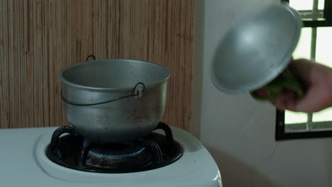 lifting lid from hot rice pot and turning off gas stove – static shot