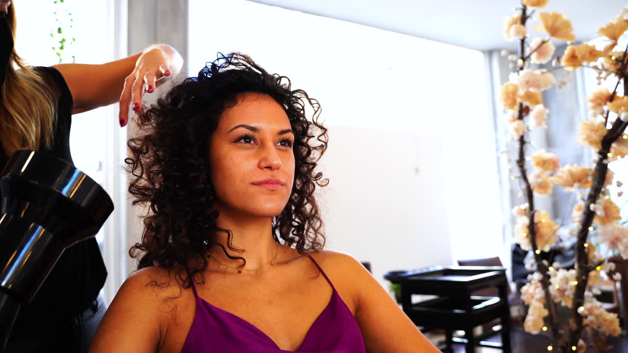 peluquero profesional haciendo peinado a una cliente de cabello largo