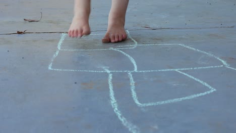 child playing hopscotch outdoors