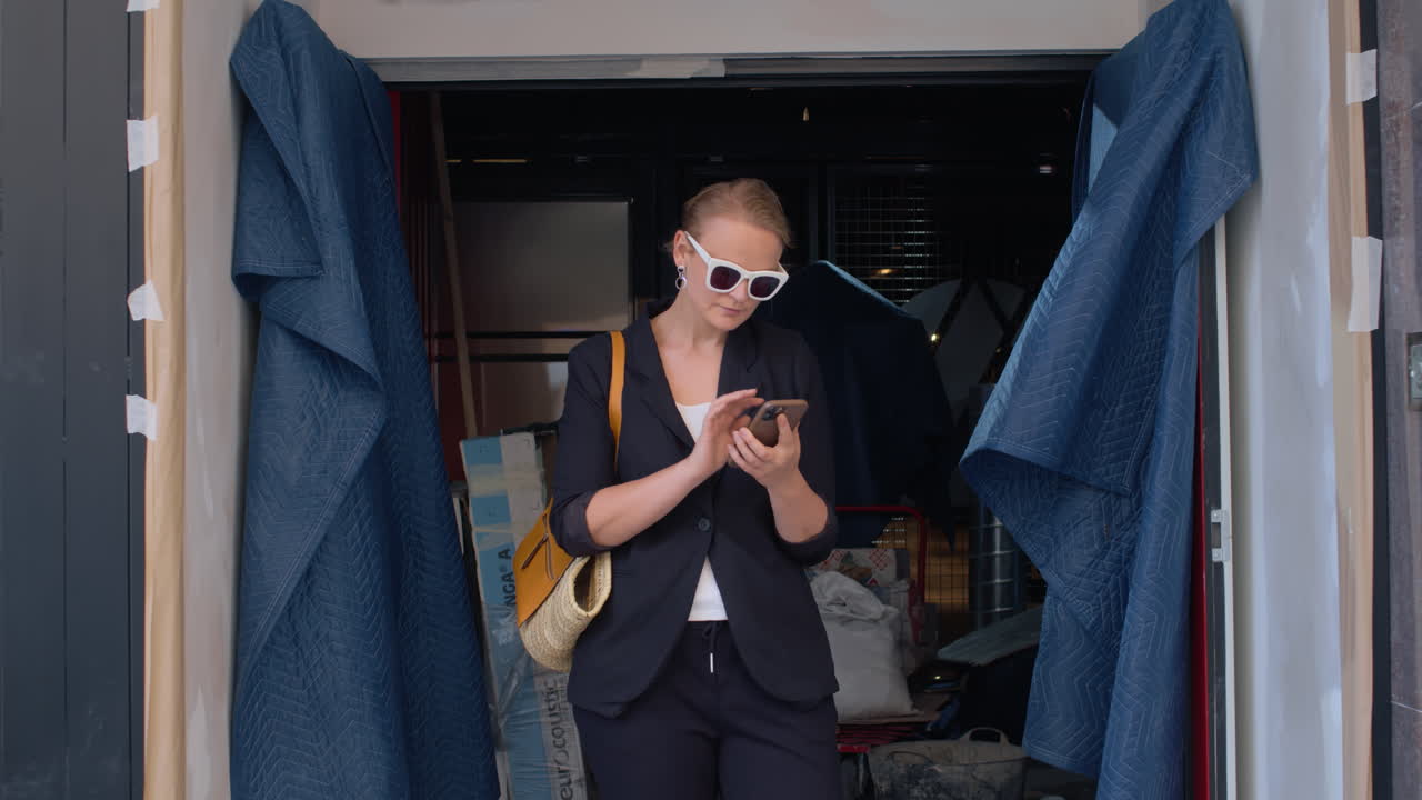 한 젊은 여성이 건설 중인 가게의 입구에 서 있습니다.