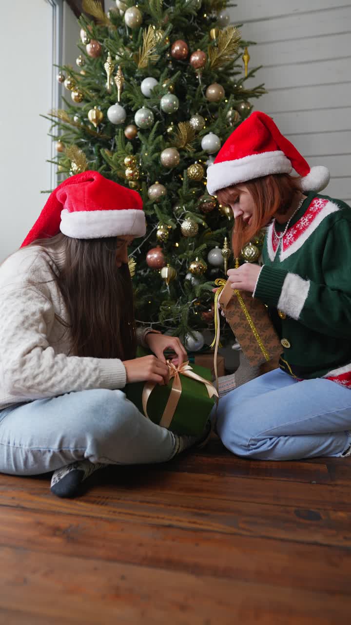 amigos abriendo regalos de navidad junto al árbol de navidad