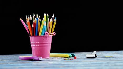 Color-pencils-in-pencil-holder-with-school-supplies-on-table