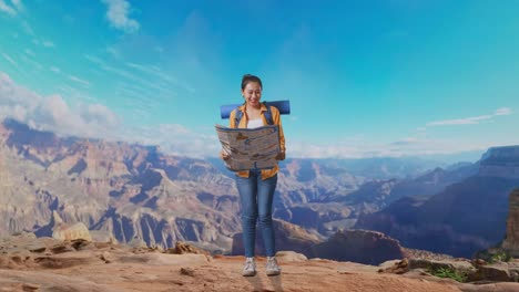 full body of asian female hiker with mountaineering backpack looking at the map then smiling to camera while traveling at the top of mountain