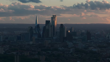 tight aerial slider shot of london city skyscraper cluster lit by the sunset