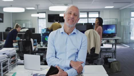 retrato de un hombre sonriendo mientras usa una tableta digital en la oficina
