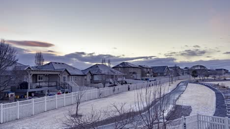 Static-time-lapse-of-a-snow,-frosty-suburban-neighborhood-with-clouds-moving-overhead