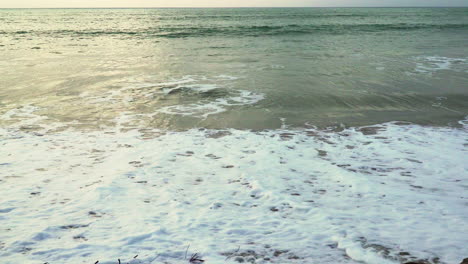 the foam is produced by the tides of the sea washing up the shore of zorritos beach in tumbes, peru