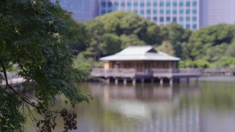 Desenfoque-De-Fondo-De-La-Casa-De-Té-Y-El-Estanque-En-Los-Jardines-Hamarikyu-En-Tokio