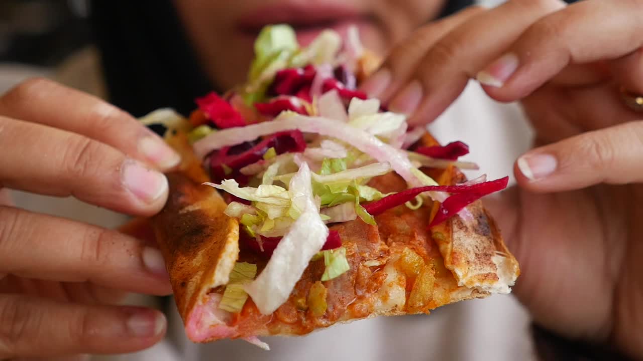 Close-up of Hands Holding and Eating a Delicious Kebab Wrap