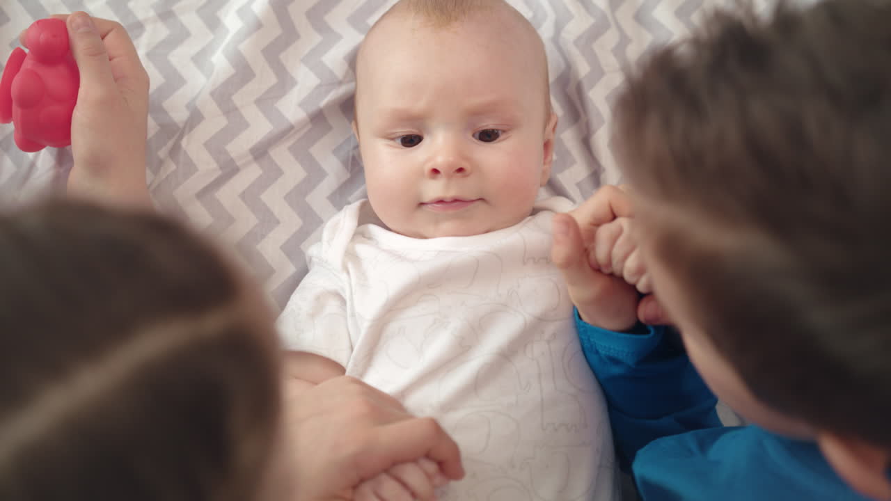 사랑스러운 아기를 보는 형제자매. 큰 아이들은 작은 아이를 돌봅니다. 아이들은 사랑합니다.