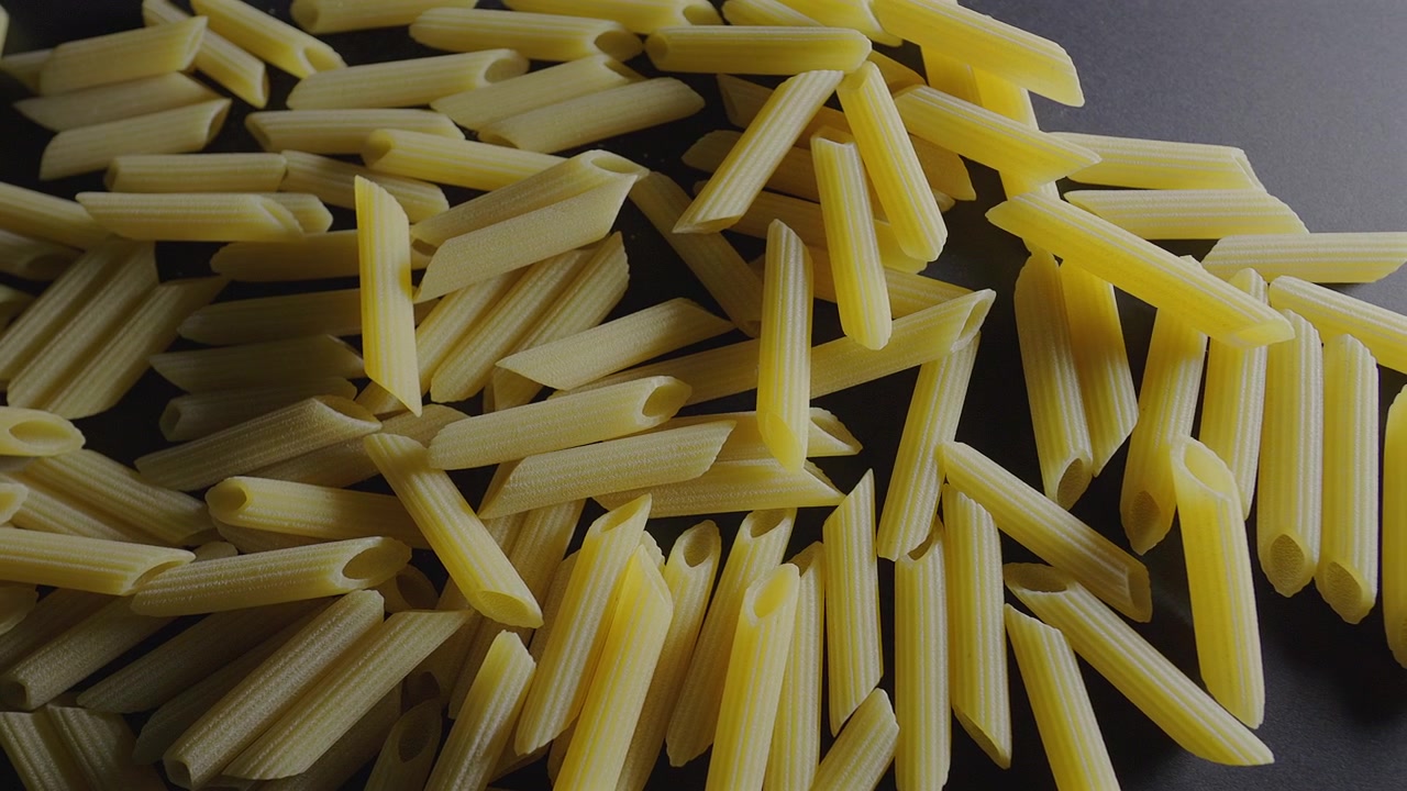 Ripresa macro con slider che si muove su pasta penne italiana cruda.