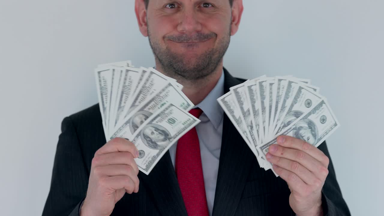 un hombre de negocios codicioso está agitando un paquete de dinero en efectivo frente a él