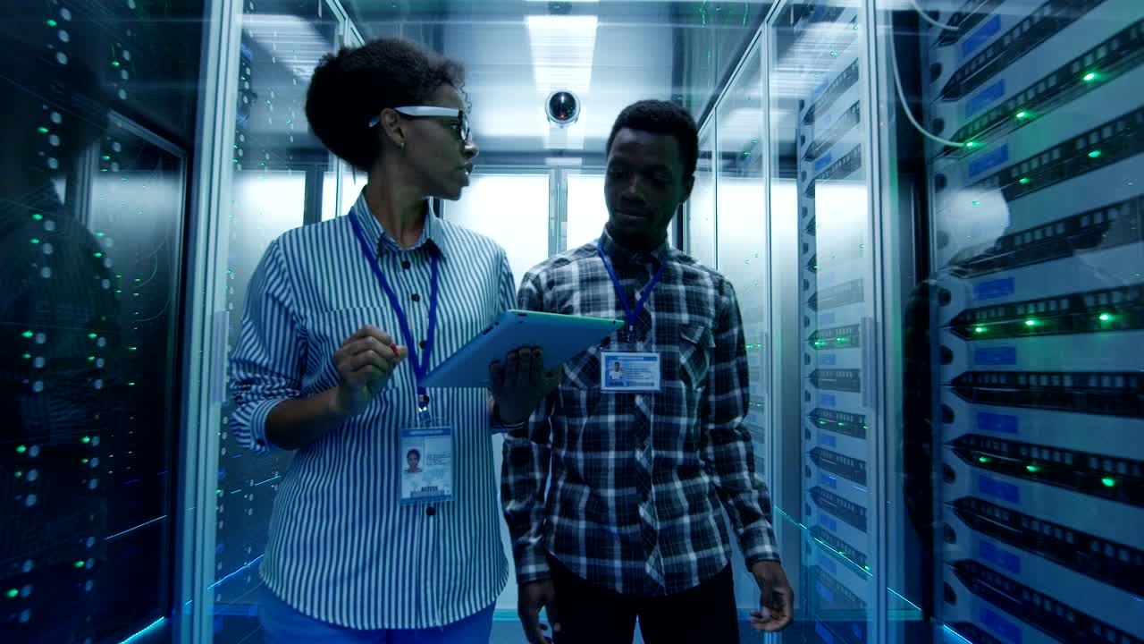 especialistas de ti étnicos con tableta en la sala del servidor