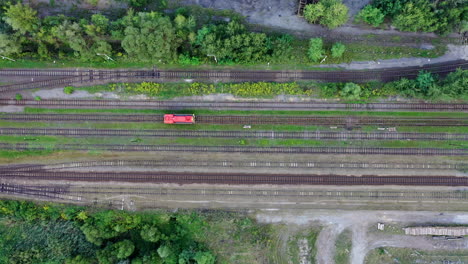vía de tren roja recta que corre junto con los campos agrícolas en la puesta de sol de verano