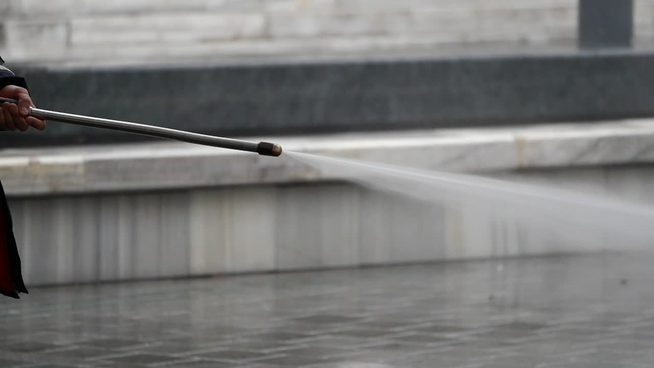 limpiando una calle de la ciudad con una lavadora a presión