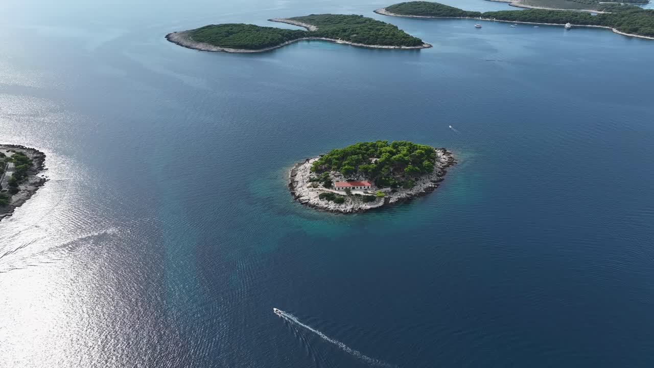 Establishing drone shot of small island during the day with sunshine and Adriatic Sea in Hvar, Croatia