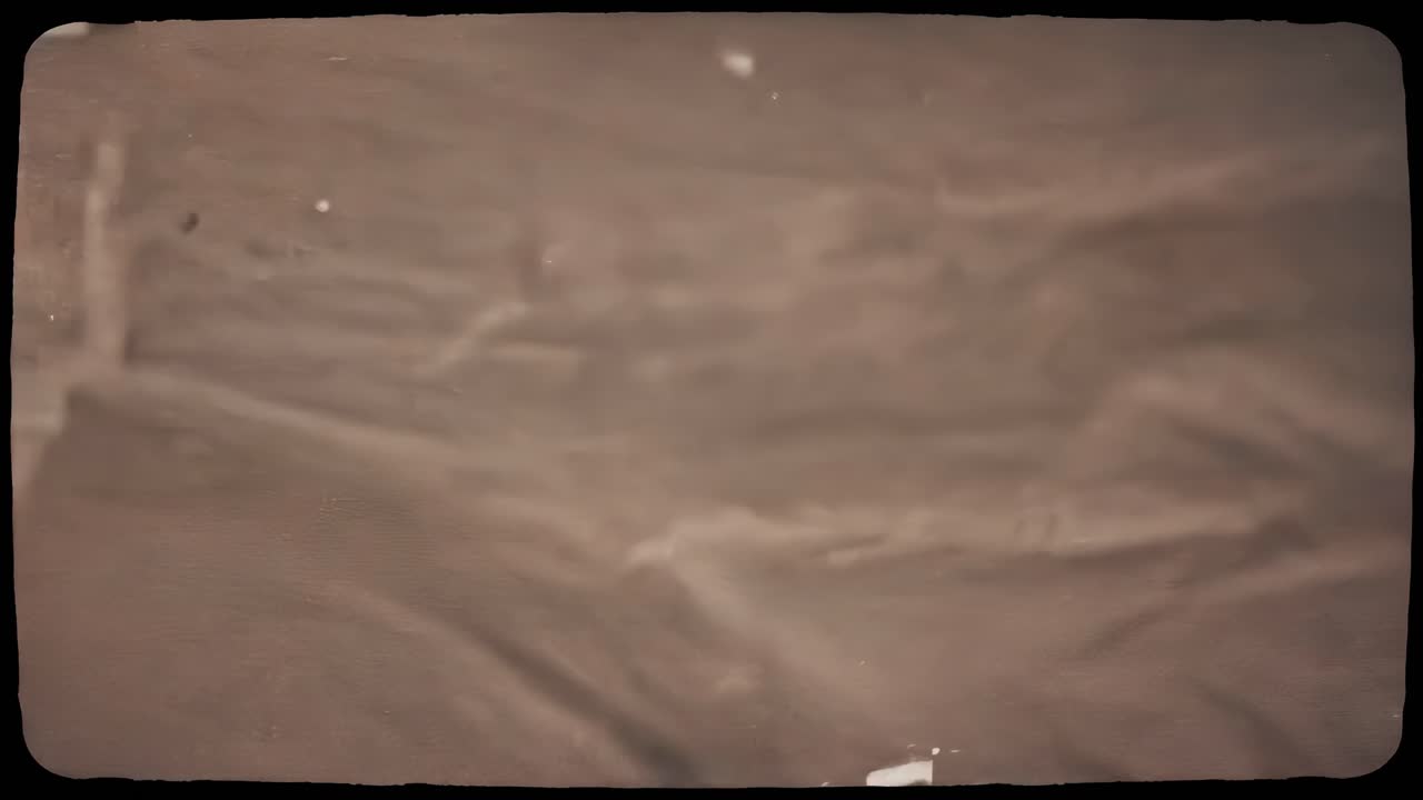 Vintage-style video with a top-down angle, capturing the subtle textures of a dark, grainy surface