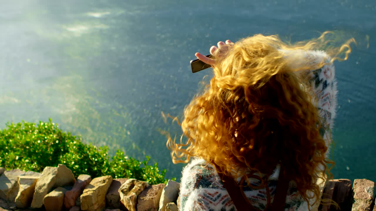 женщина, стоящая возле моря в солнечный день 4k