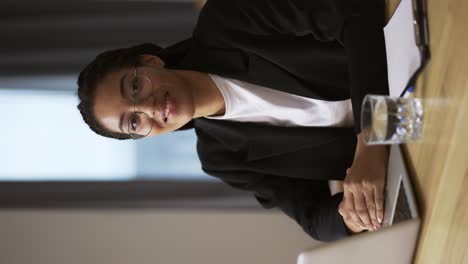 Smiling-girl-secretary-business-woman-sitting-at-table-at-office,-portrait-footage