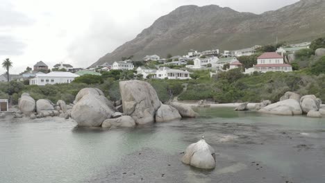 mountains in the background of boulders beach in cape town, south africa on a cloudy day
