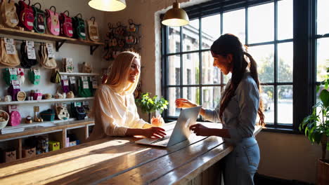 two women interacting at a counter in a retail store