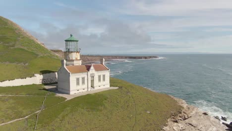 historic lighthouse on cliff side, drone pull away to reveal point conception