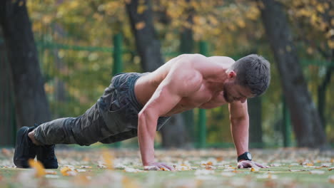 young sportsman doing push ups. handsome sport man doing push ups in the park