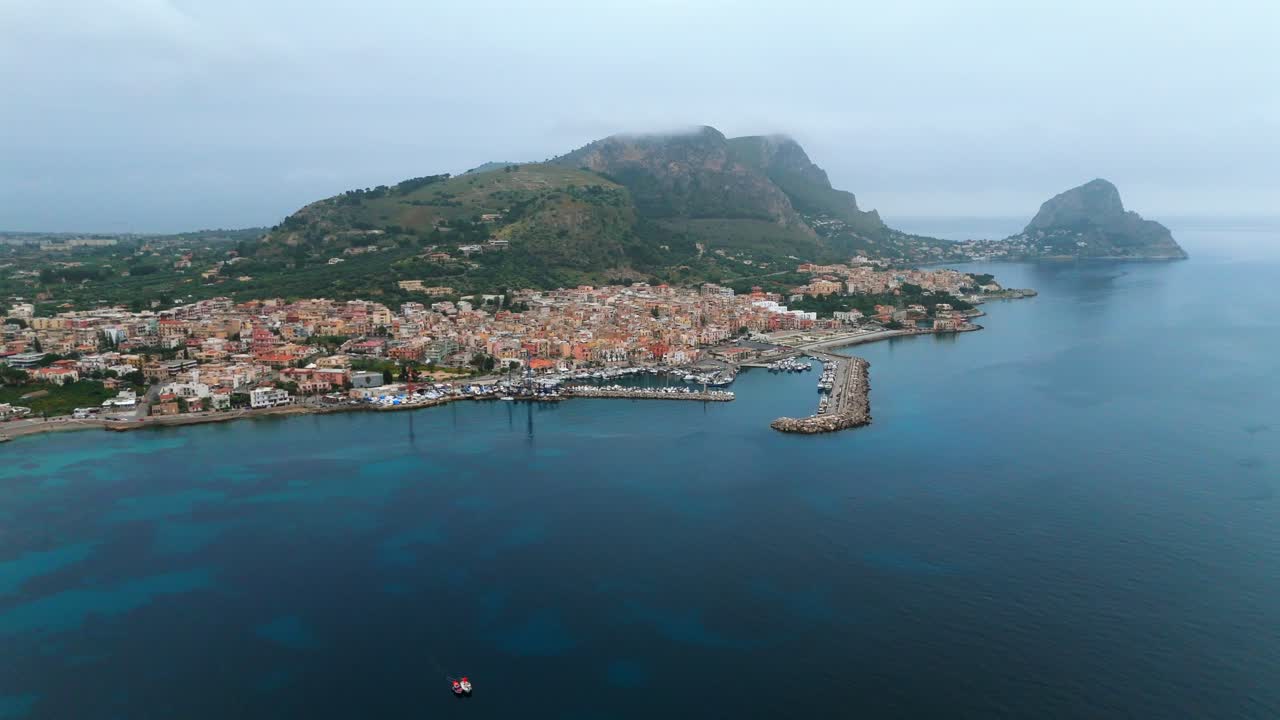 Aerial footage of Porticello’s coastline and marina in Sicily, Italy, with a boat returning from the location of the sunken Bayesian yacht off the coast