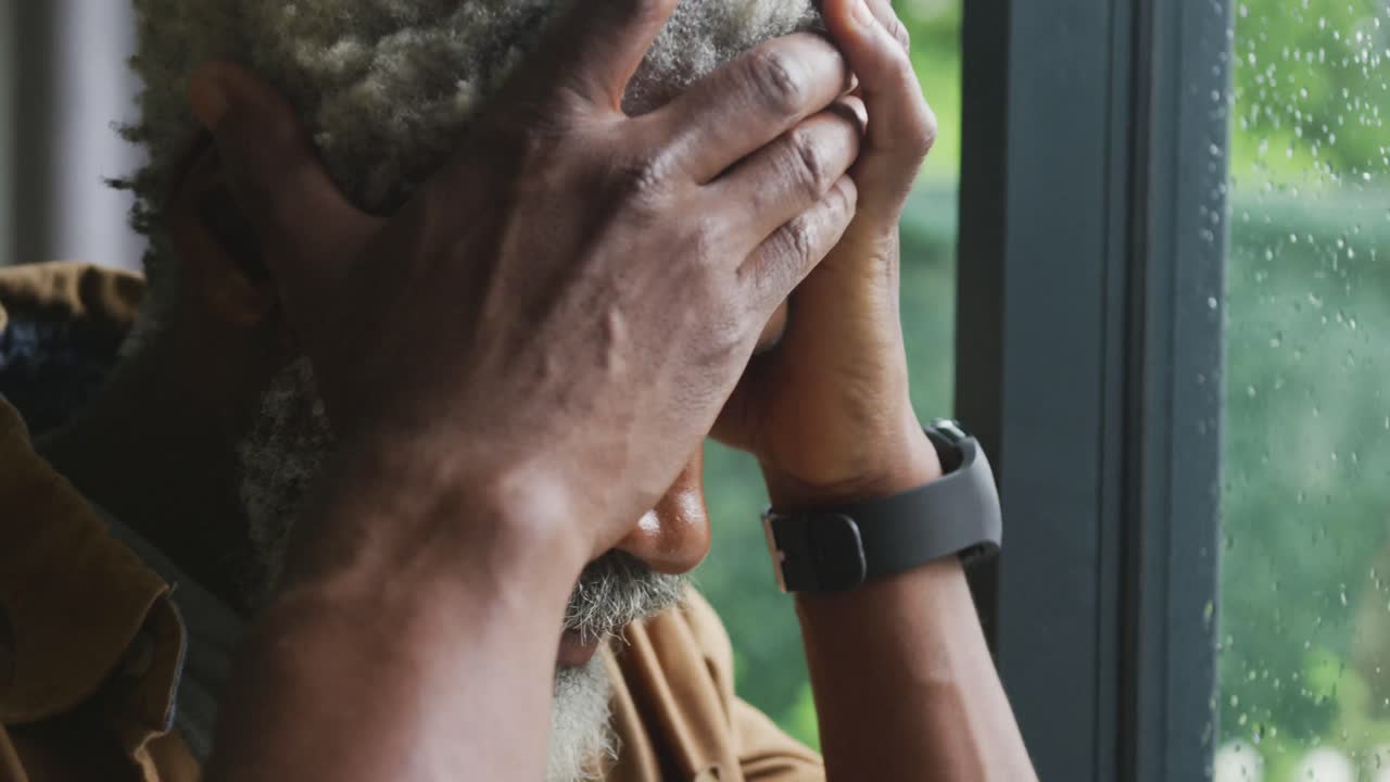video de un triste hombre mayor afroamericano mirando por la ventana