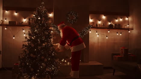 santa claus brings gifts under the christmas tree for children. give gifts to children on christmas night. santa puts a gift under the christmas tree. high quality 4k footage