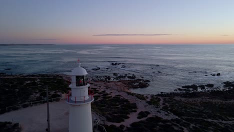 Corny-Point-lighthouse-aerial-shot-in-evening-with-flashing-light-beacon-on-Yorke-Peninsula-coast,-South-Australia