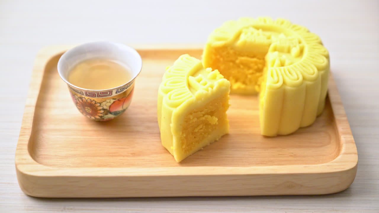 나무 접시에 차를 곁들인 중국 월병 커스터드 맛