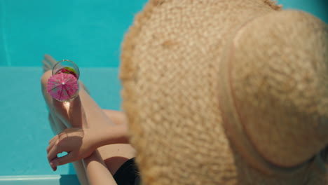 woman relaxing in pool with cocktail