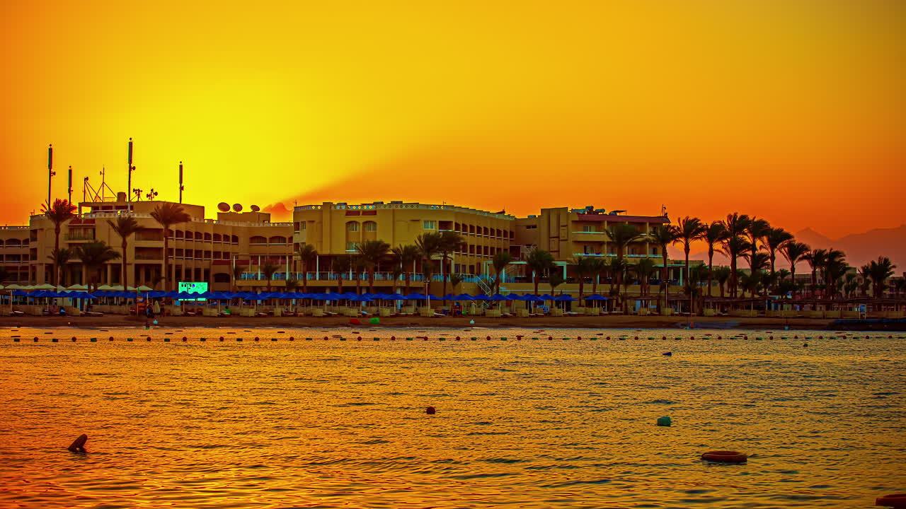 해가 뜰 때 비치 리조트 뒤에서 빛나고 떠오르는 태양, - 타임랩스