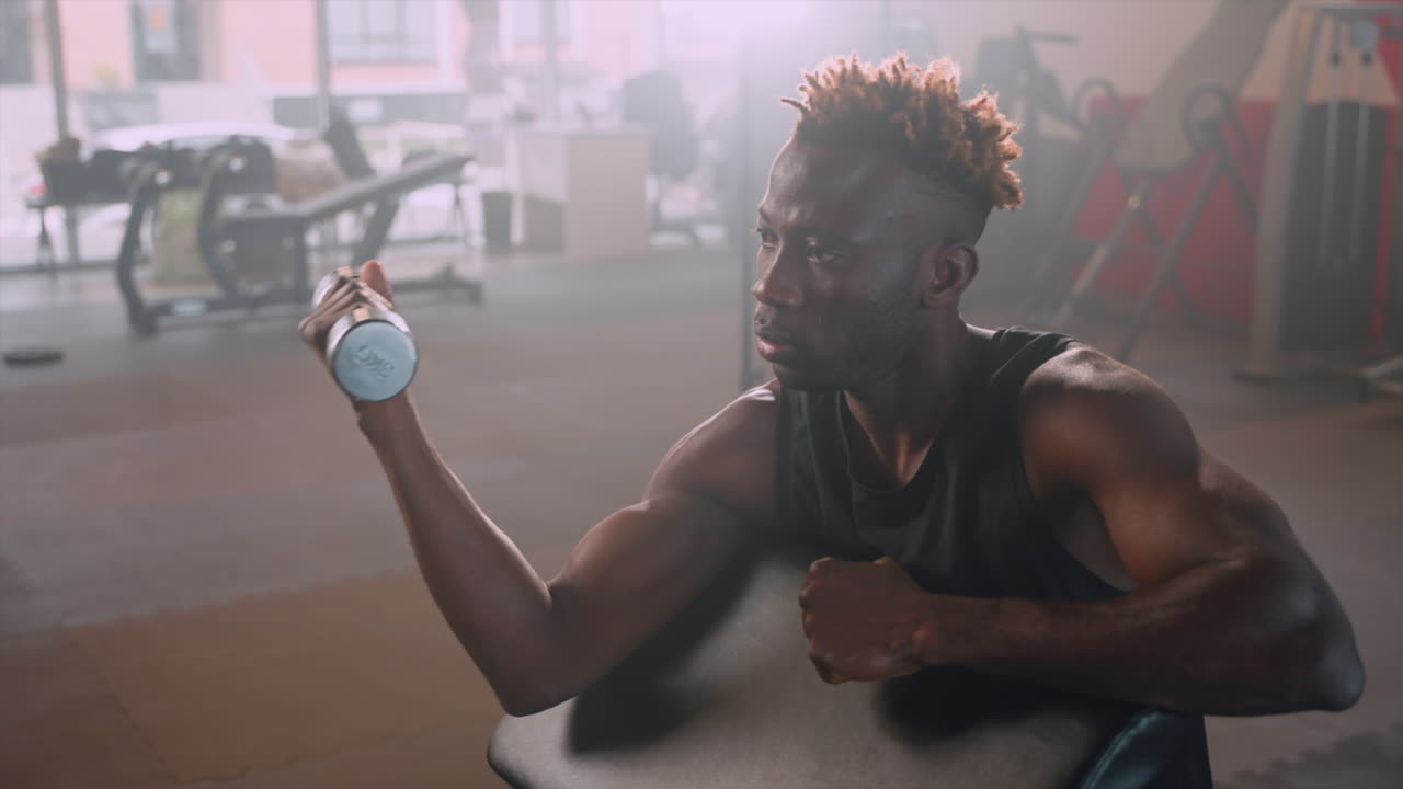 Man Working Out with Dumbbells in a Gym